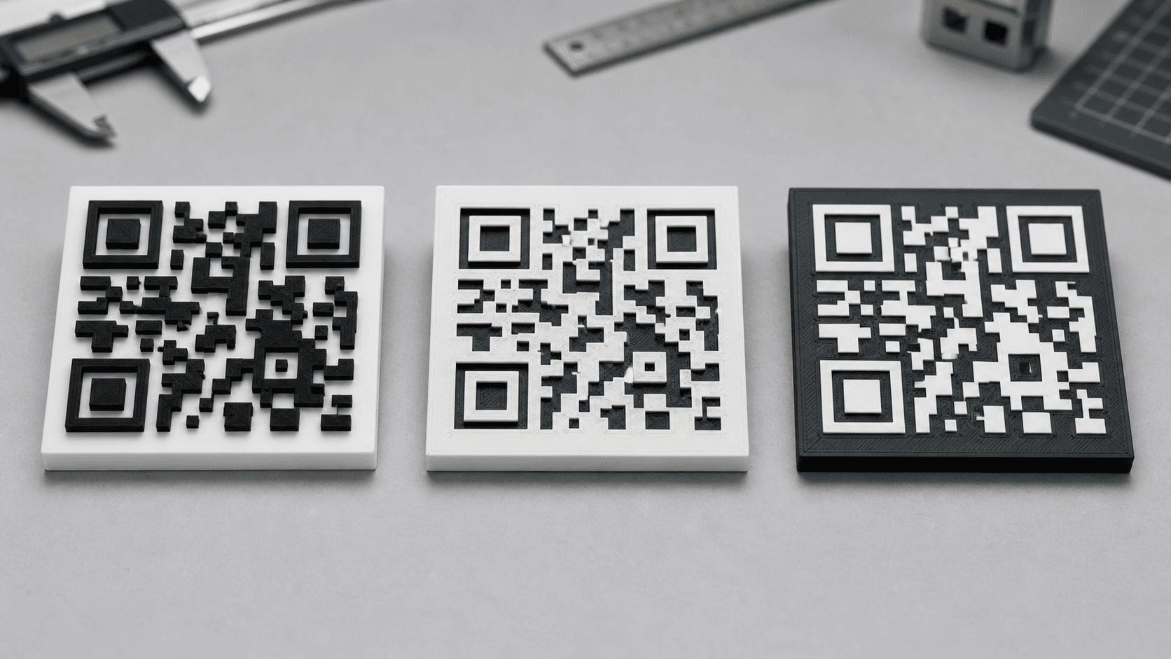 Raised Recessed and Two-Color 3D Printed QR Codes Three 3D printed QR code plaques comparing raised recessed and two-color designs